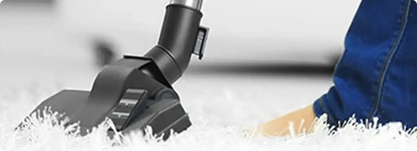 Close-up of a professional vacuuming a white carpet in Pasadena.